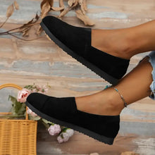 Two black round toe flats with textured soles
