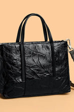 Black crinkled leather handbag with textured tote design and detachable strap