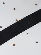 Black elastic wide belt with gold buckle, textured weave, and coffee beans