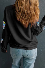 Woman in black ghost round neck long sleeve sweatshirt and blue jeans