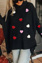 Black oversized heart patched turtleneck sweater with red, pink, and white hearts