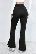 Black high-waisted flared pants with side slits and stretchy fabric