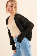 Black chunky knit bolero cardigan with pom-poms and ribbed cuffs
