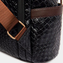 Black leather backpack bag with woven texture, brown straps, zipper, and gold hardware