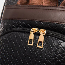 Black leather backpack bag with brown straps, gold hardware, and woven texture