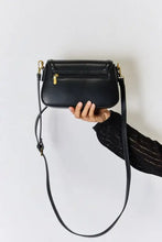 Black leather crossbody bag with gold hardware and adjustable strap