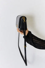 Black leather crossbody bag with gold hardware and adjustable strap