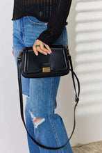 Elegant black leather crossbody bag with gold hardware and adjustable strap