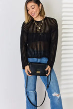 Black leather crossbody bag with gold hardware and mesh sweater