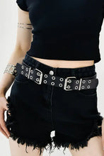 Black leather two row eyelet belt with double silver buckles on denim shorts