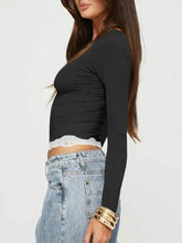 Black long sleeve crop top with white lace trim and gold bracelets