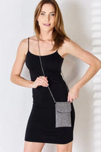 Woman in black mini dress with Forever Link rhinestone mini crossbody bag