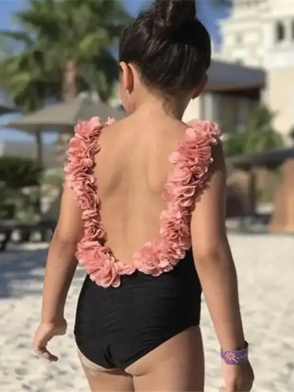 Stylish black one-piece swimsuit with pink floral ruffle back at Hipomarket