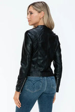 Woman in black PU leather jacket with zipper closure and blue jeans