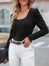 Woman in black ribbed scoop neck puff sleeve top with white jeans