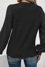 Schwarzes Langarmshirt mit rundem Ausschnitt und gerippten Ballonärmeln
