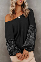 Black sequin puff sleeve top with ribbed hem and bell sleeve length