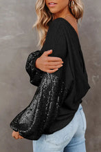 Black sequin puff sleeve top with ribbed hem and bell sleeve length