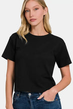 Woman in black short sleeve cropped t-shirt with round neck and blue jeans