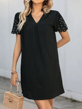 Black stretch polka dot puff sleeve dress with V-neck, ruffles, and pockets