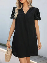 Black stretch polka dot puff-sleeve mini dress with pearls, ruffles, pockets