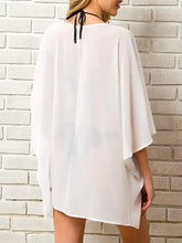 Woman’s white sheer half sleeve cover-up with black halter neck