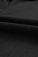 Black pleated skirt with textured fabric and short sleeve V-neck top