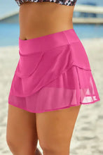 Black tiered swim skirt in solid pattern with hot pink pleated mesh overlay