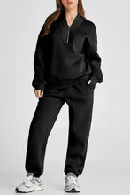 Black zip-up tracksuit with drawstring waist and full length joggers, white sneakers