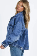 Blue acid wash denim jacket with rolled-up sleeves, button closure, and oversized pockets