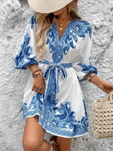 Blue and white floral print dress with puff sleeves, V-neckline, and tie waist