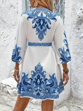 Blue and white floral dress with V-neckline, tie waist, and bell sleeves
