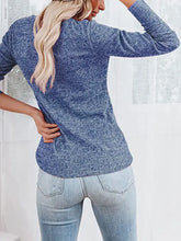 Woman in buttoned long sleeve round neck henley shirt and distressed jeans