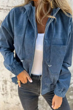 Blue corduroy bomber jacket with hood, pockets, and zipper closure