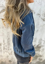 Blue corduroy jacket with hood, zipper closure, buttons, and long sleeves