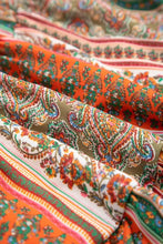 Vibrant orange-green paisley scarf with boho multicolored striped dress and brown leather boots