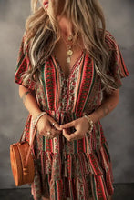 Boho multicolored striped tiered dress with deep V-neck, ruffled hem, short sleeves, woven straw handbag, and brown leather boots