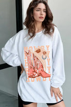Woman in graphic round neck long sleeve sweatshirt with cowboy hat and boots