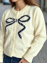Cremefarbener Cardigan mit Rundhalsausschnitt, Schleifenknöpfen, marineblauem Schleifendesign und Knopfverschluss in Größe