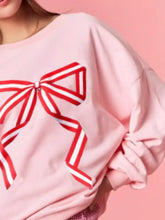 Pink oversized bow crew neck sweatshirt with bold red and white striped bow graphic machine wash cold recommended