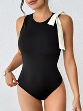 Black sleeveless bodysuit with satin white bow detail tied at the shoulder in a one-piece design
