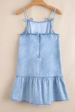 Light blue denim dress with spaghetti straps and ruffle hem featuring a bow detail for a stylish look