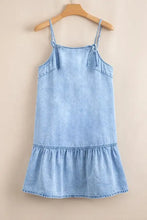 Light blue denim dress with spaghetti straps and ruffle hem featuring a bow detail for a casual look