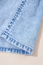 Light-wash denim dress with visible stitching along the seam featuring ruffle hem and spaghetti straps detail
