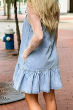 Light blue denim dress with spaghetti straps featuring a ruffle hem and sheer lace long sleeves