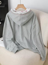 Gray heathered long sleeve hoodie with bow embroidery, soft floral inner lining, and ribbed cuffs for comfort