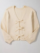 Cream-colored long sleeve cardigan with three front bows