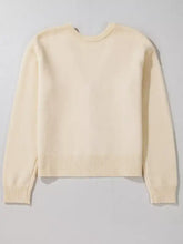 Cream-colored bow front long sleeve cardigan with ribbed cuffs