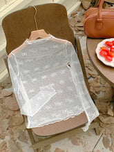 A delicate white bow embroidery sheer mesh top with scalloped edges displayed on a wooden hanger