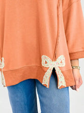 A soft peach oversized bow slit round neck sweatshirt with delicate floral lace bow hem and slightly stretchy fabric care instructions machine wash